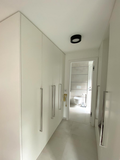 In dem sanierten Wohnhaus in Gießen bieten geräumige Schränke im Flur Zugang zu einer hellen und modernen Toilette. 