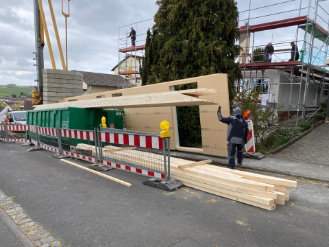 Im Sanierungsprozess des Wohnhauses werden die neuen Wände des ersten Stocks angebaut, wodurch die Struktur des Gebäudes neu gestaltet wird."