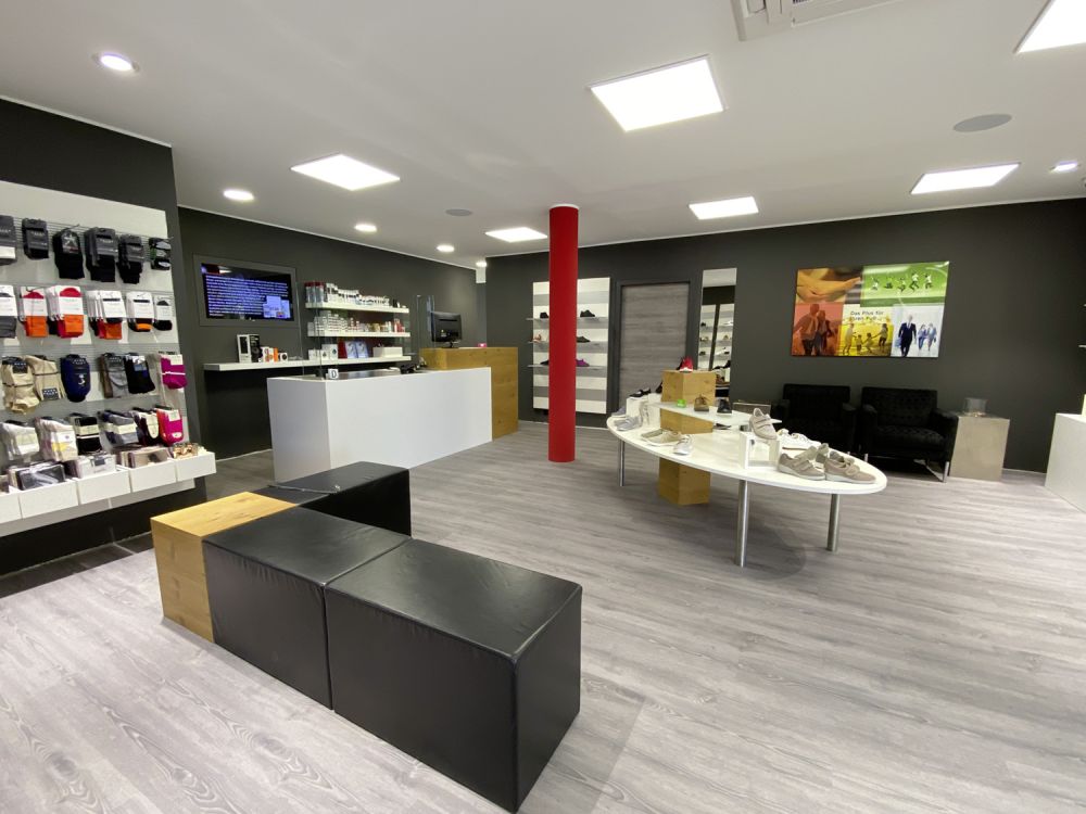 Offen gestalteter Verkaufsraum bei Fischer Fussfit in Burglengenfeld. Großzügige Raumgestaltung für ein angenehmes Einkaufserlebnis. Klare Anordnung von Regalen und Präsentationsbereichen für Übersichtlichkeit.