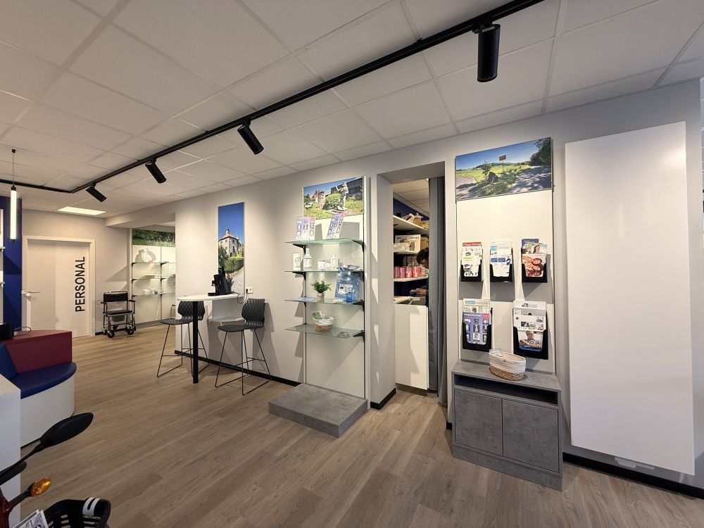 Durchdachtes Design von Bäuerlein Objektdesign trifft auf Funktionalität. Helle Farben, hochwertige Materialien und eine klare Raumstruktur schaffen eine angenehme Atmosphäre für Kundinnen und Kunden. Informationsmaterialien und Produktpräsentationen sind übersichtlich platziert.