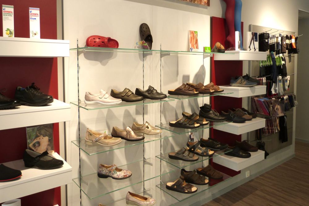 Ein Wandregal mit Schuhen in unserem Ladendesign von Bäuerlein Objektdesign