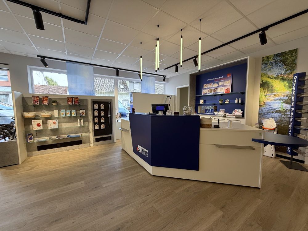 Funktional gestalteter Kassenbereich von Bäuerlein Objektdesign mit abgesenkter Kassenzone für Rollstuhlnutzer:innen. Im Hintergrund wurde eine Furniturenwand integriert.