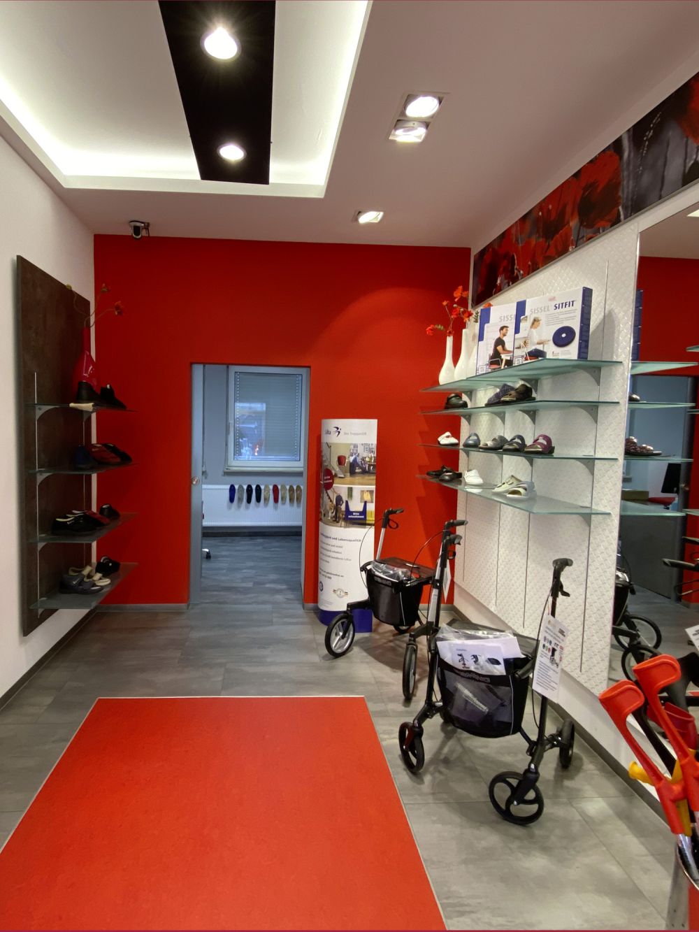 Effizient gestalteter Verkaufsraum im Schuhhaus Dorsch in Würzburg mit Wandregalen entlang des Flurs. Stilvolle Präsentation von Schuhen in angenehmer Atmosphäre.
