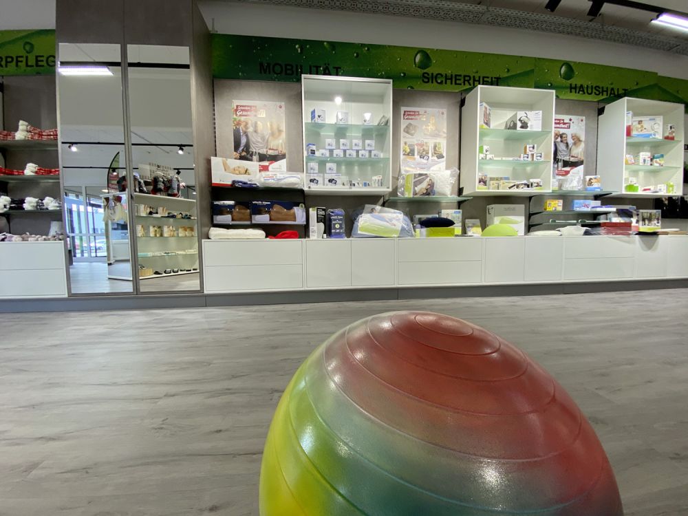 Stilvoll gestaltete Wandansicht mit integrierten Präsentationsflächen und eleganten Schubkästen von Bäuerlein Objektdesign