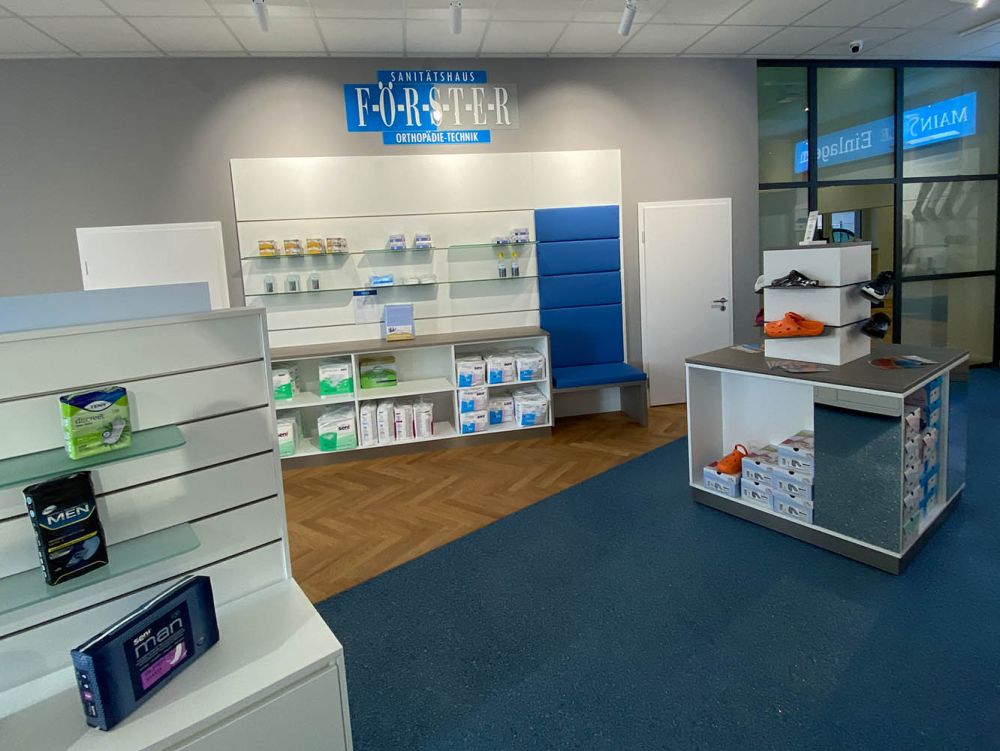Großzügige Präsentationsflächen im Wandbereich und als freistehende Elemente prägen das moderne Design des Sanitätshauses. Die klare Gestaltung und hochwertige Materialien ermöglichen eine strukturierte Darstellung orthopädischer Hilfsmittel und Produkte.