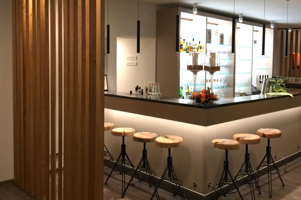 Bar mit Barhockern im Restaurant in Baden-Württemberg, gestaltet von Bäuerlein Objektdesign.