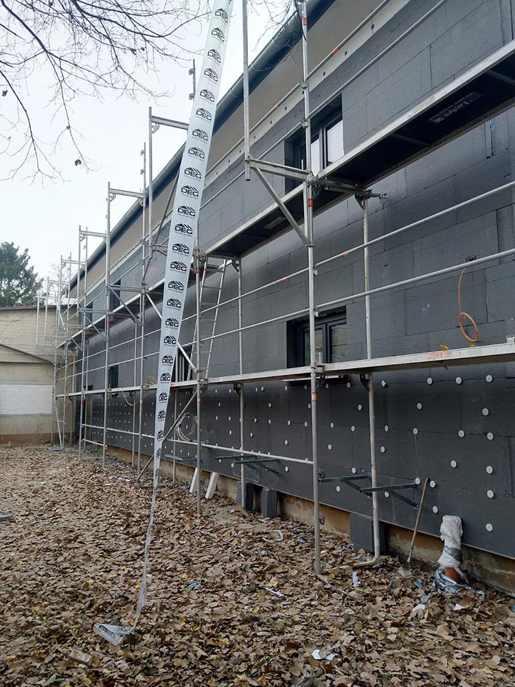 Bild von den laufenden Fassadenarbeiten am Sanitätshaus Förster in Frankfurt. Experten von Bäuerlein Objektdesign verbessern und verschönern die äußere Gestaltung des Gebäudes.