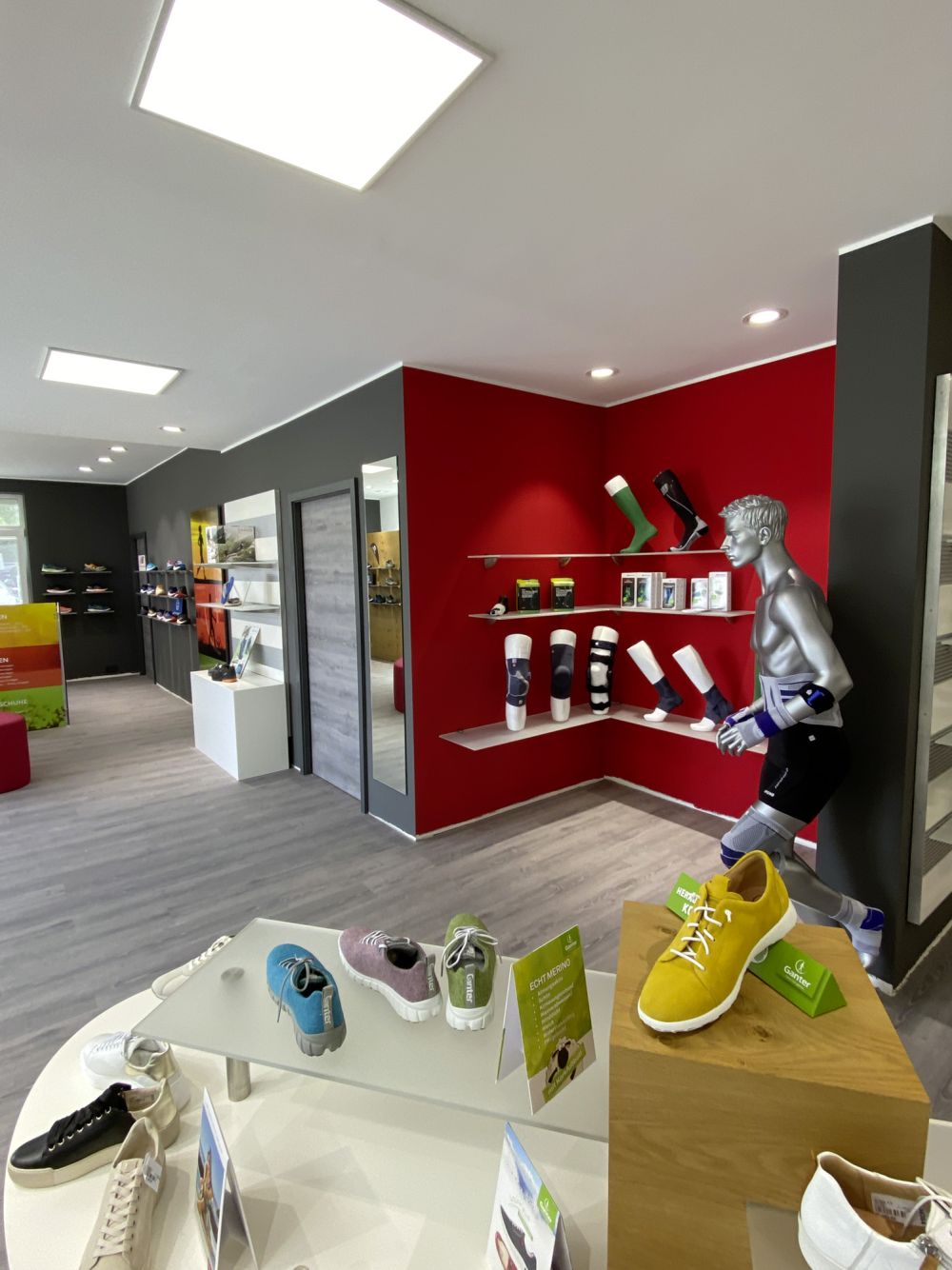 Wandpräsentation mit flexibel einsetzbaren Elementen zur übersichtlichen Darstellung orthopädischer Hilfsmittel. Die modulare Gestaltung ermöglicht eine individuelle Anpassung an wechselnde Produktpräsentationen.