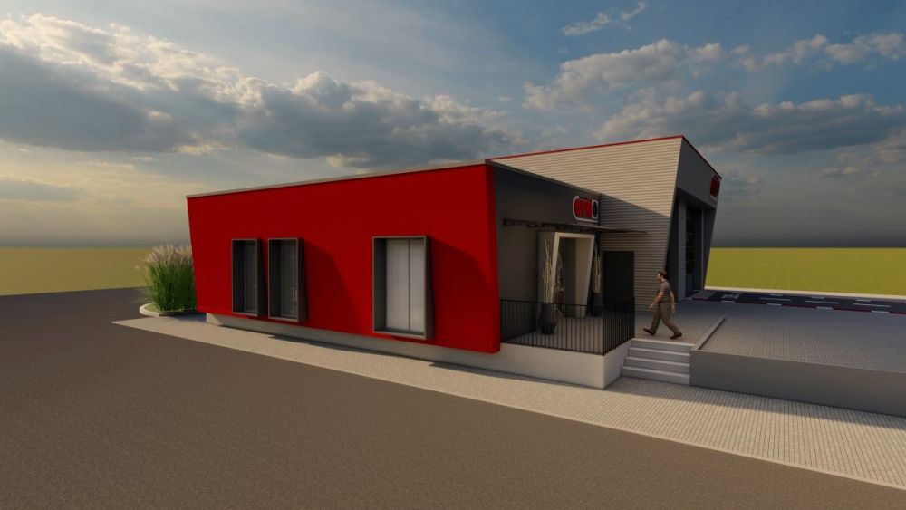 Fassade in rot grauer Farbkombination mit großformatigen Fensterelementen, die der Gebäudeansicht eine moderne, offene Wirkung verleihen. Die kontrastreiche Farbgestaltung betont die klare Linienführung und unterstreicht den zeitgemäßen Charakter der Architektur.